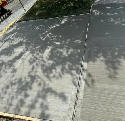 Sidewalk repair in NYC with new concrete flags under tree shade