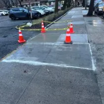 DOT sidewalk violation repair marked with traffic cones